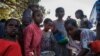 Des enfants déplacés du Tigré se rassemblent à l'heure des repas pour recevoir de la nourriture à l'extérieur d'une salle de classe de l'école où ils s'abritent à Mekele, la capitale du Tigré, en Éthiopie, le 24 février 2021.