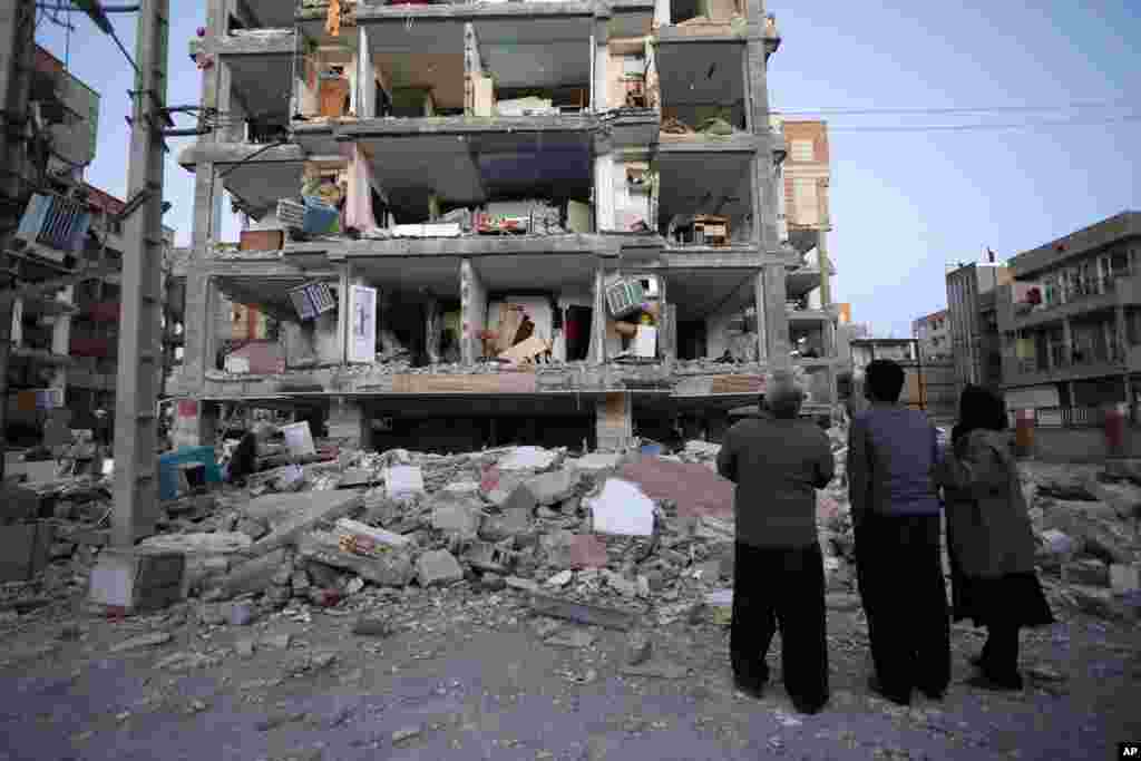 Sur cette photo fournie par l'ISNA, les habitants regardent les bâtiments détruits après un tremblement de terre dans la ville de Sarpol-e-Zahab dans l'ouest de l'Iran, lundi 13 novembre 2017.