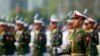 FILE - Myanmar soldiers parade during a ceremony to mark the 69th anniversary of Union Day in Naypyitaw, Myanmar. Kyaw Swa Naing and editor Kyaw Min Swe were arrested in June after a military officer filed a complaint against them. 