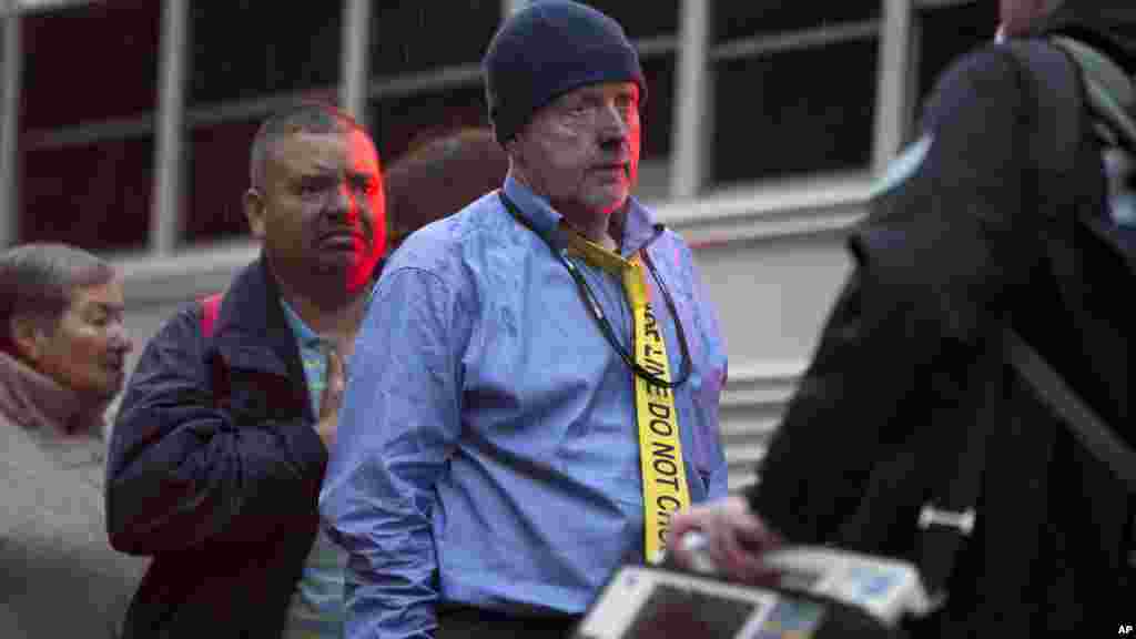 Un homme porte une cravate indiquant que la police a fait une barrière et une zone de contrôle après avoir été évacués d'un tunnel de métro enfumé à Washington, lundi 12 janvier 2015. 