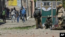 Des manifestants lancent des pierres sur des éléments des forces de sécurité indiennes devant un bureau de vote lors d'une élection partielle au Cachemire indien, le 9 avril 2017.