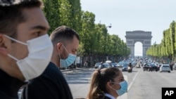 隨著法國逐步解除Covid-19封鎖，人們戴上口罩以幫助遏制冠狀病毒在巴黎香榭麗舍大道上的傳播。 (2020年5月16日)