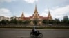 អ្នក​បើក​ម៉ូតូ​ម្នាក់ បើកម៉ូតូ​ខាងមុខ​​​អគារ​វិមាន​រដ្ឋសភា​ជាតិ​នៅ​រាជធានី​ភ្នំពេញ​កាល​ពី​ថ្ងៃ​ទី​២៦ ខែ​សីហា ឆ្នាំ​២០១៤។ (REUTERS)