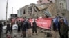 Residents walk though the site of a suicide attack in Kabul, Afghanistan, March 2, 2018. A large explosion in the eastern part of the Afghan capital on Friday morning killed at least one person and wounding others an Afghan official said. 