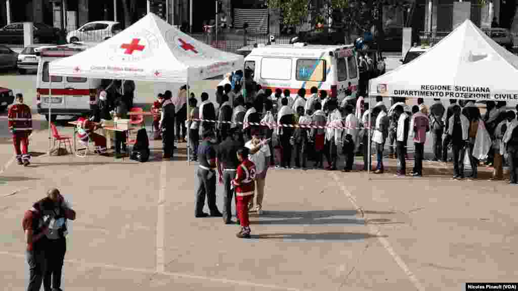 File d'attente des des migrants avant de passer dans un centre médical de la CRoix Rouge italienne à Messine, Sicile, 6 octobre 2015 (Nicolas Pinault/VOA).