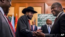 Le président du Soudan du Sud, Salva Kiir, et le chef de l'opposition Riek Machar, à droite, se serrent la main lors des pourparlers de paix dans un hôtel à Addis Abeba, Ethiopie, 21 juin 2018. 