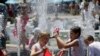 Children play in the fountain in the scorching heat at the Australian Open tennis championship in Melbourne, Australia, Thursday, Jan. 16, 2014. 