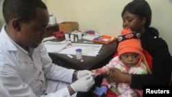 Un médecin examine un enfant contre le paludisme dans un hôpital d'Arusha, en Tanzanie, le 11 mai 2016.