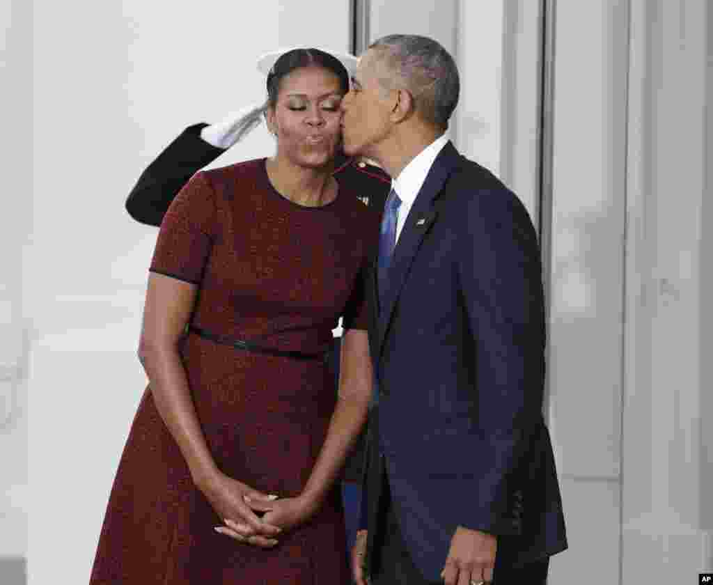 Barack Obama embrasse la Première dame Michelle Obama alors qu'ils attendent pour le président élu Donald Trumpet sa femme Melania, le 20 janvier 2017, à la Maison Blanche à Washington.