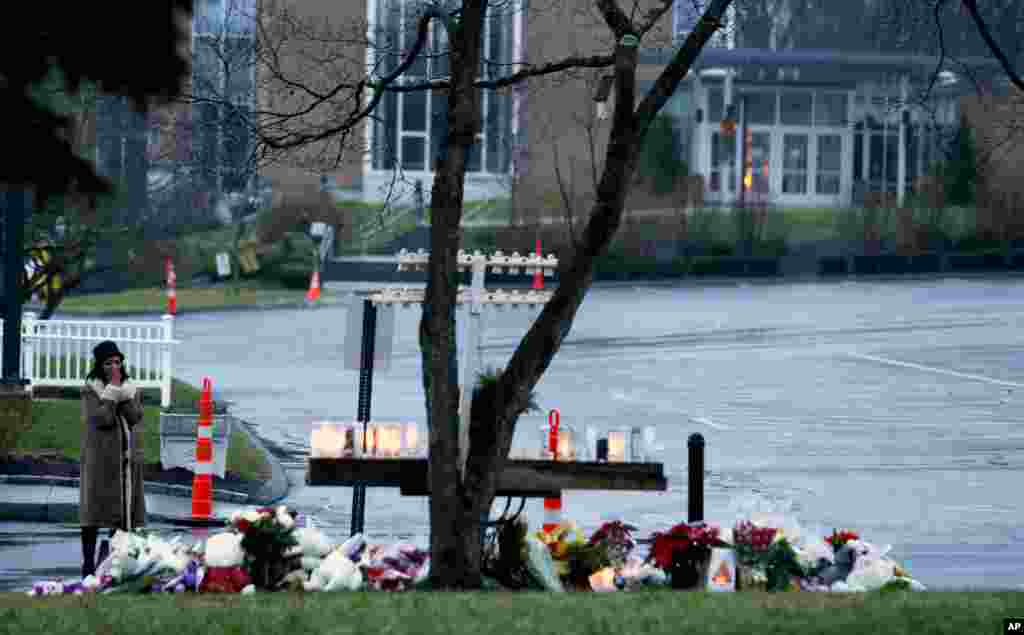 Une femme priant devant un mémorial improvisé à l'église catholique Sainte Rose de Lima de Newtown