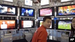 在2006年北京國際廣播電影電視設備展上，一位男士站在一系列電視機前。（資料圖片）