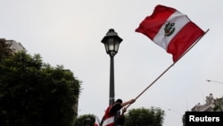 Un partisan du candidat présidentiel péruvien Pedro Castillo brandit le drapeau national au lendemain du second tour des élections, à Lima, au Pérou, le 7 juin 2021. 