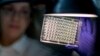 FILE - A microbiologist reads a panel to check on a bacterium's resistance to an antibiotic in the Infectious Disease Laboratory at the federal Centers for Disease Control and Prevention in Atlanta.