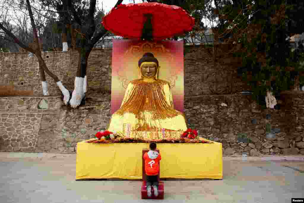 2018年2月17日，北京春节庆祝中国农历新年期间，一个男孩在八大处公园的一座佛教寺庙拜佛。