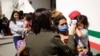 Un oficial de Aduanas y Protección Fronteriza de Estados Unidos habla con los migrantes después de que fueron detenidos y puestos bajo custodia, el domingo 21 de marzo de 2021, en Abram-Perezville, Texas.