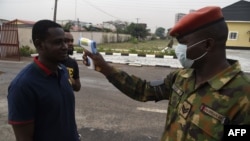 Nan wani soja ne yake gwada zafin jikin wani mutum da ya kai ziyara asibitin soji da ke Yaba a jihar Legas 