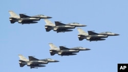 台灣空軍的F-16戰機編隊從台南空軍基地上空飛過。（2014年1月16日）