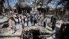 FILE- In this Oct. 13, 2016 file photo, members of the Higher Council for Civilian Community Organization inspect a destroyed funeral hall as they protest against a deadly Saudi-led airstrike on a funeral hall six days ago, in Sana'a, Yemen. 