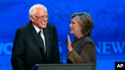 លោក​ស្រី​ Hillary Clinton (ខាង​ស្តាំ) និយាយ​ទៅ​កាន់​លោក Bernie Sanders នៅ​អំឡុងពេល​សម្រាក​នៅ​ក្នុង​ការ​ជជែកដេញដោល​សម្រាប់​បេក្ខជន​ប្រធានាធិបតី​គណបក្ស​ប្រជាធិបតេយ្យ។
