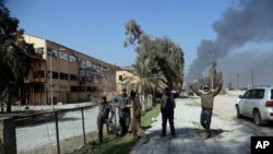 Des hommes de la police fédérale irakienne en liesse après la reprise de l'aéroport dans l'ouest de Mossoul, en Irak, le 24 février 2017