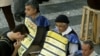 Un hombre desempleado que busca trabajo entre hombres que usan pancartas que muestran ofertas de empleo, en el centro de Sao Paulo, 23 de julio de 2003.