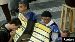Un hombre desempleado que busca trabajo entre hombres que usan pancartas que muestran ofertas de empleo, en el centro de Sao Paulo, 23 de julio de 2003.