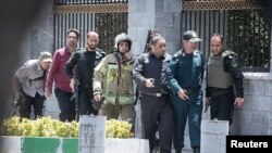 Des membres des forces iraniennes pendant l'attaque contre le Parlement, à Téhéran, le 7 juin 2017.