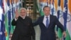 India's Prime Minister Narendra Modi, left, escorted by Australian Prime Minister Tony Abbott, waves as they leave the House of Representatives at Parliament House in Canberra, Tuesday, Nov. 18, 2014.