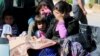 FILE - Civilians, allegedly wounded by Islamic State fighters, wait with relatives to cross into Turkey at the Syrian-Turkish border crossing of Tel Abyad, Syria, June 25, 2015.