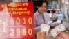 FILE - A currency trader counts Cambodian riels to exchange for U.S. dollars at a money exchange stall in the capital Phnom Penh, Cambodia, Feb. 15, 2008. Cambodia racked up $278 million in U.S. loans under the Lon Nol government in the 1970s.