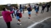 Une enseignante prend la température de chaque élève avant la classe dans le canton de Langa au Cap, Afrique du Sud le 8 juin 2020. (REUTERS/Mike Hutchings)