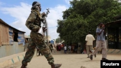 Un soldat somalien patrouille dans une rue à la suite d'un attentat à la voiture piégée et d'une fusillade à Afgoye, en Somalie, le 19 octobre 2016.