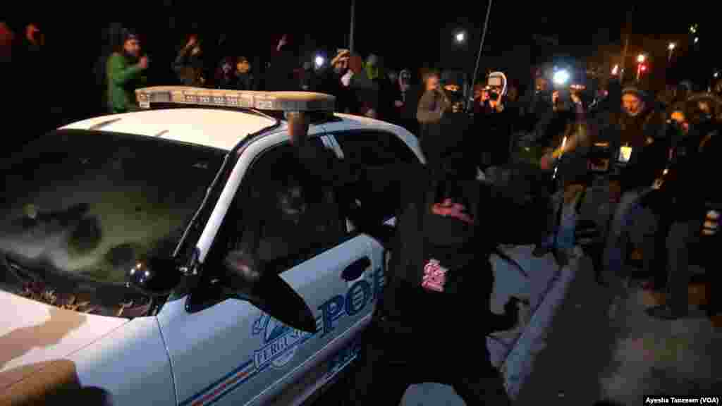 Des manifestants attaquent et renversent sur une voiture de police à l'extérieur Ferguson City Hall, à Ferguson, Missouri, le 25 novembre 2014.