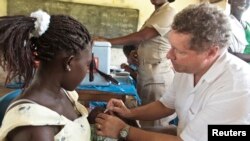 Une jeune femme se fait vacciner au Ghana
