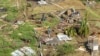 Family members survey their home, which was destroyed in the passing of Hurricane Beryl, in Ottley Hall, St. Vincent and the Grenadines, on July 2, 2024.
