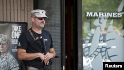 U.S. Army veteran Chris Murphy, armed with a rifle and handgun, stands near a U.S. Marines recruiting office in Everett, Washington July 23, 2015. According to the U.S. Army, citizens across the U.S. volunteered to station themselves near military recruiting centers to offer protection after the 2015 shooting in Chattanooga, Tennessee. 