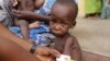 FILE - A doctor attends to a malnourished child at a refugee camp in Yola, Nigeria. 