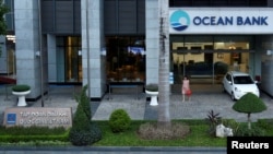  A woman walks out of a branch of Ocean Bank located in the PetroVietnam building in Hanoi, Vietnam, Sept. 1, 2017. 