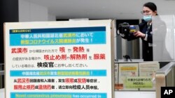 日本成田國際機場的工作人員在調整體溫監測儀以測試從中國武漢和其他城市抵達的旅客健康狀況。 （2020年1月23日）