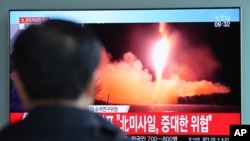 Un homme regarde le lancement d'un missile en Corée du Nord, le 29 novembre 2017.