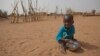 FILE - А boy is seen eating dry couscous in the village of Goudoude Diobe, in the Matam region of northeastern Senegal.