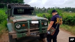Un policier inspecte un véhicule au point de contrôle où une camionette a explosé le mardi 31 juillet 2018
