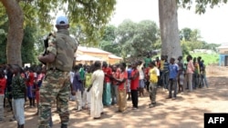 Un soldat monte la garde près d'anciens enfants soldats anti-Balaka attendant d'être libérés d'un camp à Batangafo, en République centrafricaine, 28 août 2015. AFP PHOTO / EDOUARD DROPSY 