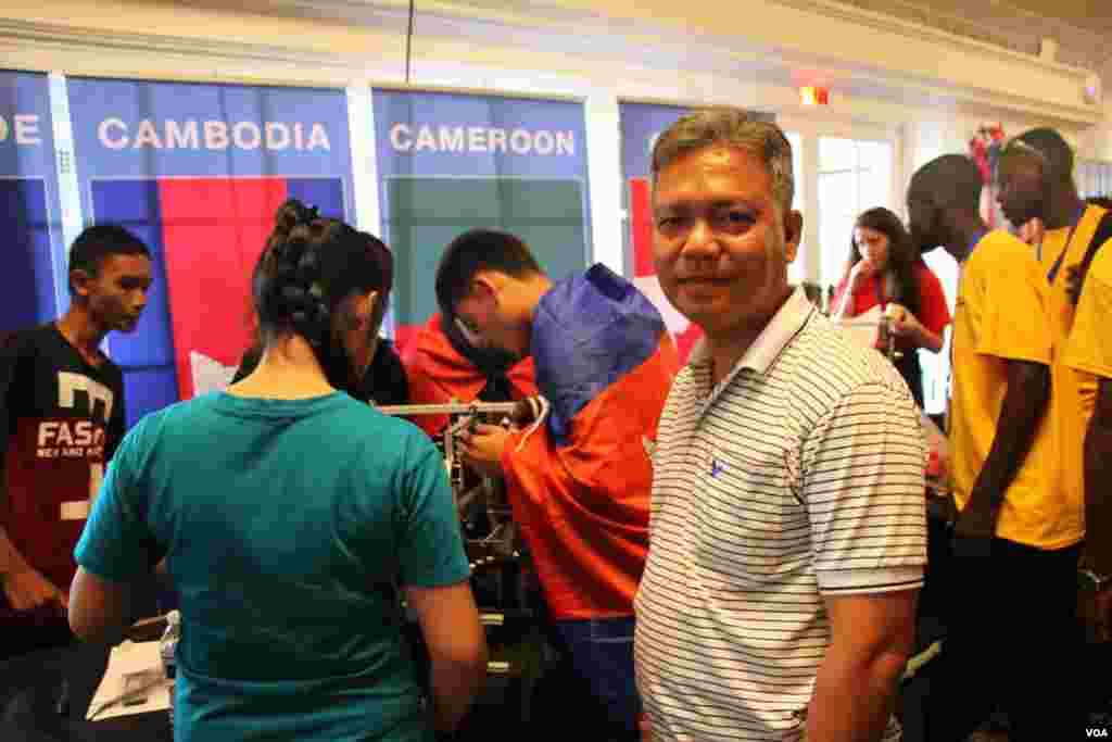 លោក អ៊ុង សាវី ប្រធានប្រចាំប្រទេសនៃអង្គការ Caring for Cambodia ដែលឧបត្ថម្ភក្រុមយុវជនកម្ពុជាពីខេត្តសៀមរាបឈរនៅក្បែរក្រុមយុវជនកម្ពុជានៅក្នុងការប្រកួតបញ្ជាមនុស្សយន្តជុំទី១មួយនៅសាលសម្តែងសិល្បៈ DAR Constitution Hall ក្នុងរដ្ឋធានី Washington នៅថ្ងៃ ទី១៧ ខែកក្កដា ឆ្នាំ២០១៧។ (សឹង សុផាត/ VOA)
