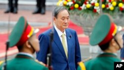 日本首相菅義偉在越南河內總統府檢閱儀仗隊。（2020年10月19日）