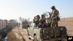 FILE - In this Dec. 22, 2015 photo, Afghan security forces patrol in Nad Ali district of Helmand province, Afghanistan. Late on Sept. 23, 2017, Taliban insurgents ambushed and killed the district police chief and his three bodyguards. 