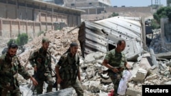 Les forces loyales au président Bachar al-Assad patrouillent dans les décombres sur le côté sud de la route Castello à Alep, en Syrie - Image fournie par SANA, le 28 juillet 2016. 