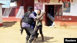 Photo d’archives : Des policiers face à un manifestant lors d'affrontements à Lubumbashi, en République démocratique du Congo, le 10 novembre 2015.