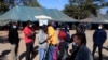Des gens font la queue pour se faire vacciner contre le COVID-19 dans une clinique de Harare, au Zimbabwe, le 8 juillet 2021.