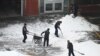 Workers clear snow from a courtyard after an overnight snowfall in Beijing on Dec. 11, 2023.